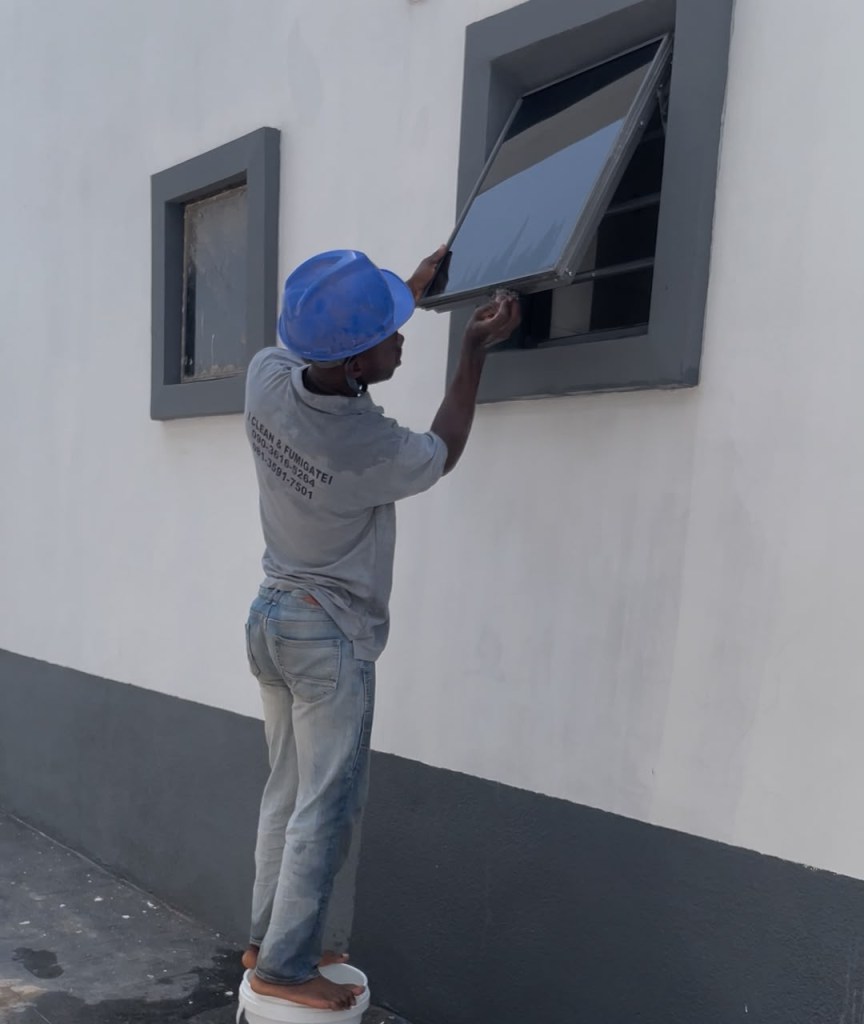 Spotless Care staff in company uniform cleaning a client site in Abuja